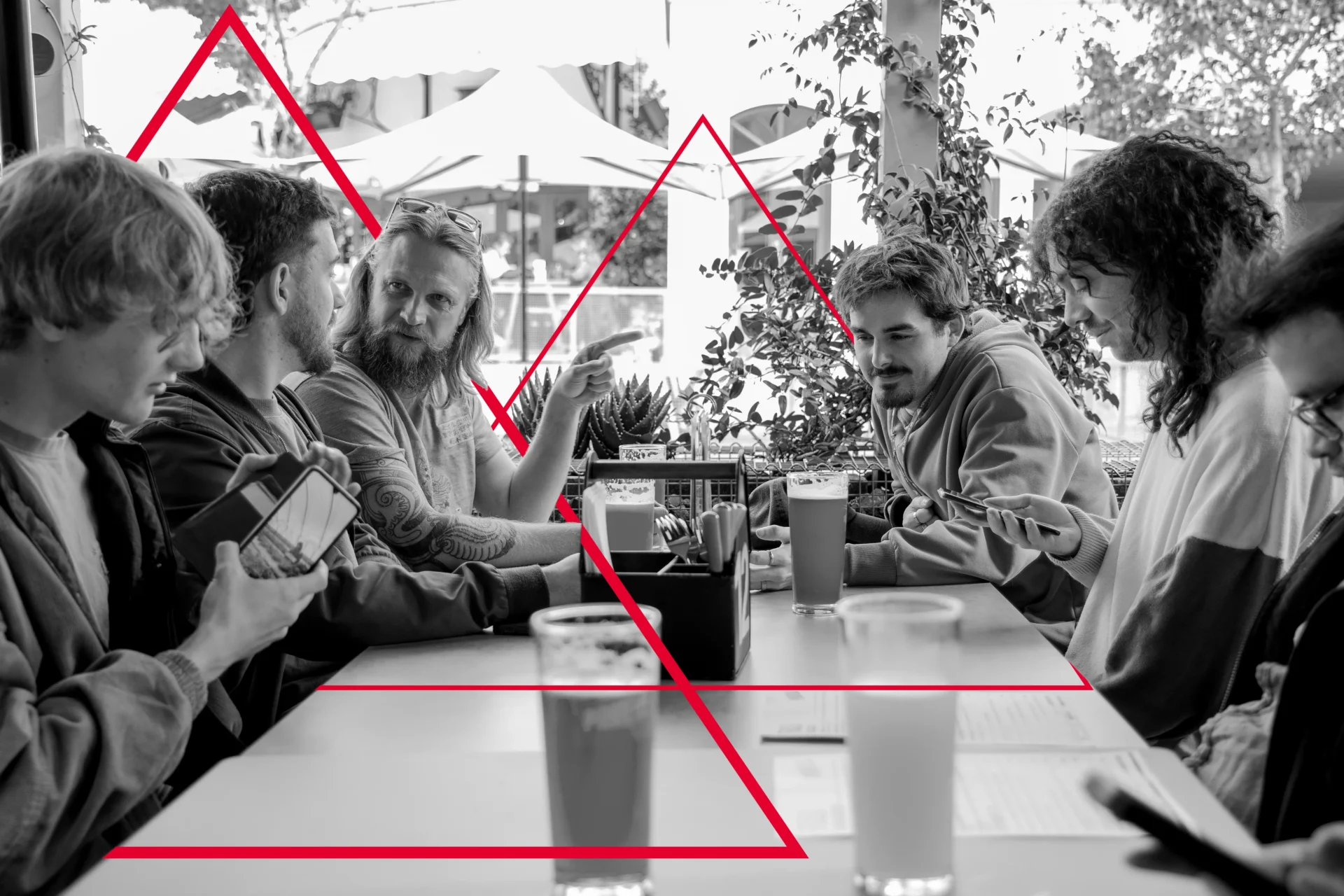 The Viewport XR team sharing lunch around a table, in black and white with the red triangle motif