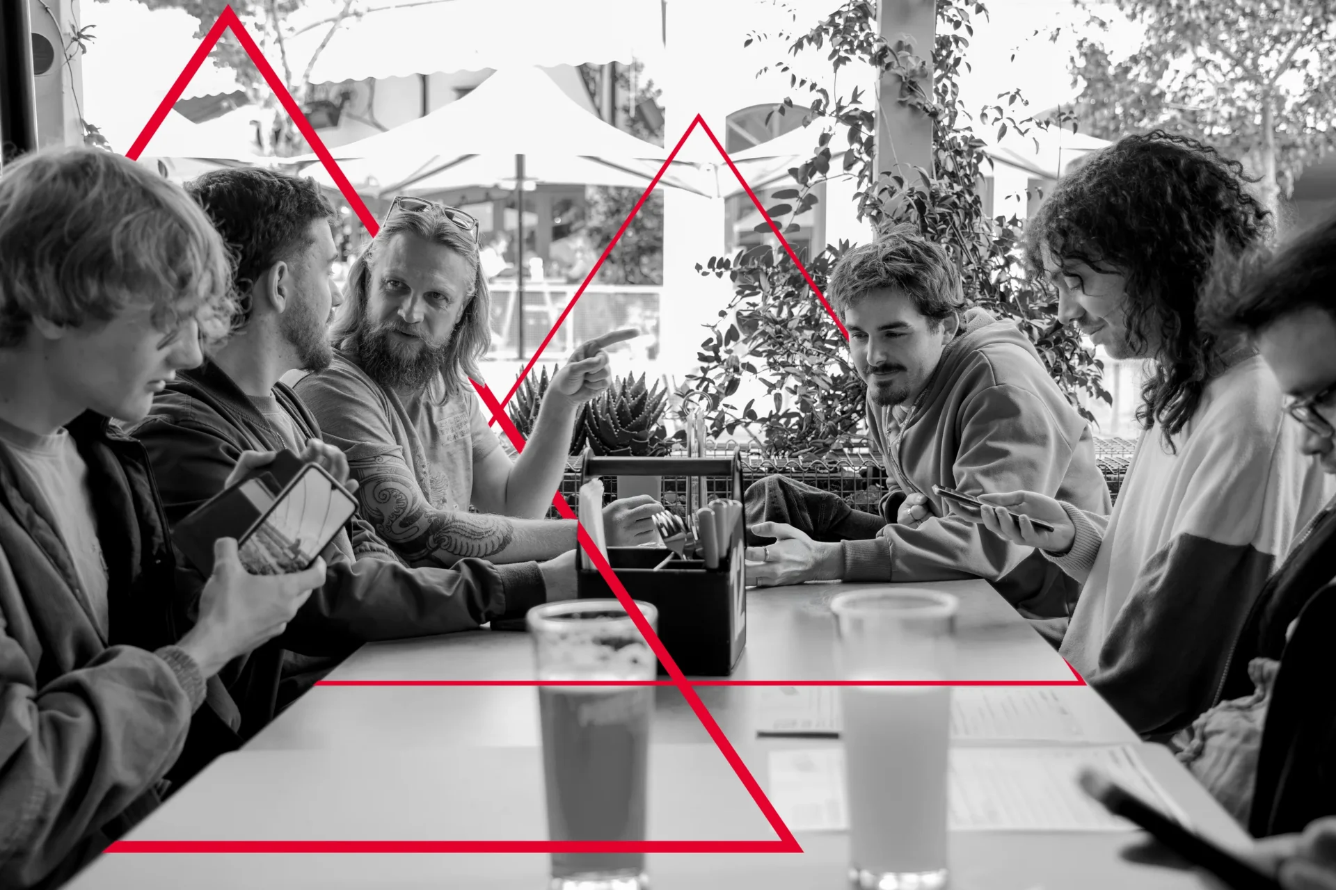 The Viewport XR team sharing lunch around a table, in black and white with the red triangle motif